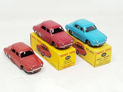 three toy cars are sitting in a box on a white surface