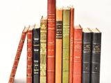 plusieurs vieux livres sont empilés sur une surface blanche