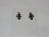a pair of silver earrings with black stones on them