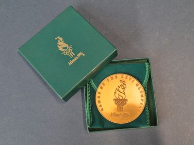 une pièce d'or dans une boîte verte posée sur une table