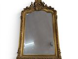 un miroir encadré d'or sur un mur blanc avec un fond blanc