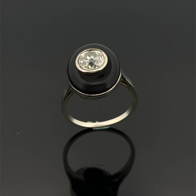 une bague en diamant noir et blanc posée sur une surface noire