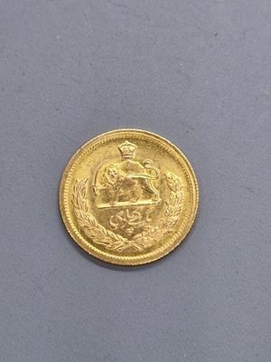 gros plan d'une pièce d'or sur une surface grise