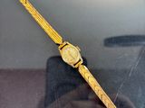 someone is taking a picture of a watch in a glass case