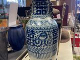 un vase bleu et blanc posé sur une table dans un magasin