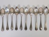 six spoons are lined up in a row on a white surface