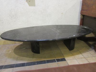 a black table with a black marble top on a tiled floor
