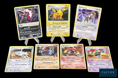 Plusieurs cartes Pokémon sont alignées les unes à côté des autres sur un fond noir