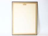 blank picture frame on a white wall with a clipboard