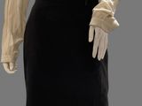 a mannequin mannequin wearing a beige shirt and black skirt