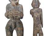deux statues en bois représentant un homme et une femme debout l'un à côté de l'autre