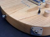 a close up of an electric guitar with a wooden body