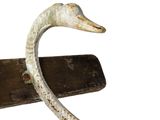 a metal sculpture of a bird that is on a wooden stand