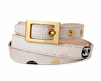 the belt is white and has a gold buckle on it
