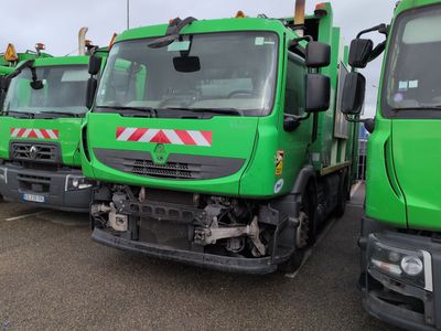 many green trucks parked in a row in a parking lot