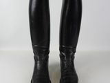 pair of black leather riding boots on white surface with white background