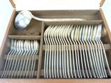 a lot of silverware in a box with a spoon in it