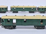 plusieurs wagons verts et jaunes alignés les uns à côté des autres sur une surface blanche