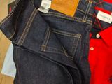 three pairs of men ' s jeans laid out on a wooden floor