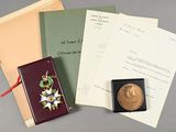 un livre, une médaille et des papiers posés sur une table