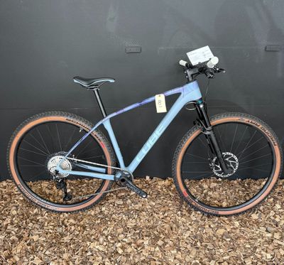 un vélo bleu appuyé contre un mur noir