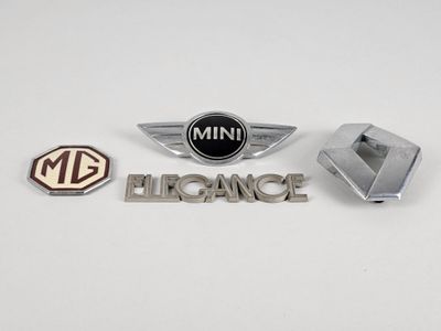 Trois emblèmes automobiles différents sont représentés sur un fond blanc