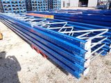a close up of a pile of blue steel beams in a warehouse
