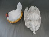 deux figurines d'anges et un poulet posés sur une table