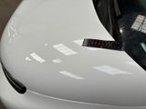 a close up of a white car with a sticker on it
