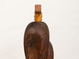 wooden bottle sitting on top of a white pedestal on a white surface
