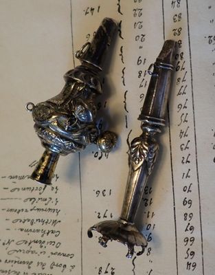 deux objets en argent posés sur un livre ouvert