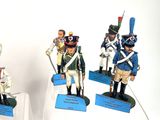 three figurines of men in uniforms of different sizes and colors