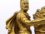 a gold statue of a man riding a horse with a lion