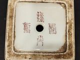 a small square vase with chinese writing on it