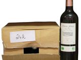 a bottle of wine next to a cardboard box with a label on it