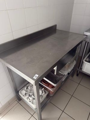 a stainless steel work table in a kitchen with pots and pans on it