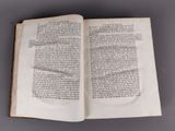 an open book on a table with a pen in it