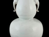 un vase blanc à deux anses sur fond noir