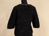 a close up of a mannequin wearing a black sweater on a mannequin stand