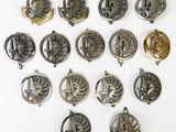 several silver and gold medals are arranged on a white surface