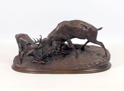 sculpture en bronze représentant un cerf et une chèvre, posée sur un socle en bois