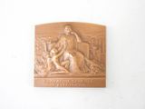 a plaque on the wall of a building with a statue of a man and a dog