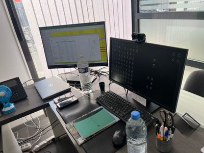 un bureau sur lequel se trouvent deux écrans d'ordinateur et un ordinateur portable