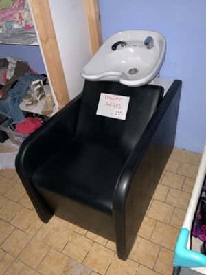 une chaise noire sur laquelle est posé un lavabo blanc