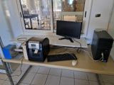 un bureau sur lequel se trouvent un ordinateur, un clavier, une souris et un écran