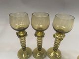 three wine glasses sitting on a table next to each other