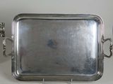 a silver tray with a handle on a table