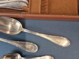 a lot of silver spoons and spoons in a box