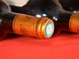 several bottles of wine are lined up on a red surface