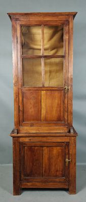 un vieux meuble en bois surmonté d'une porte en verre